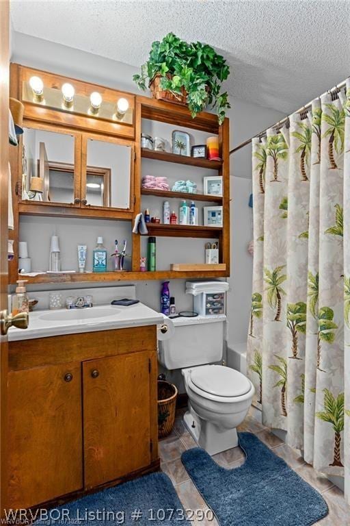 full bathroom with vanity, tile patterned flooring, toilet, shower / bath combo with shower curtain, and a textured ceiling