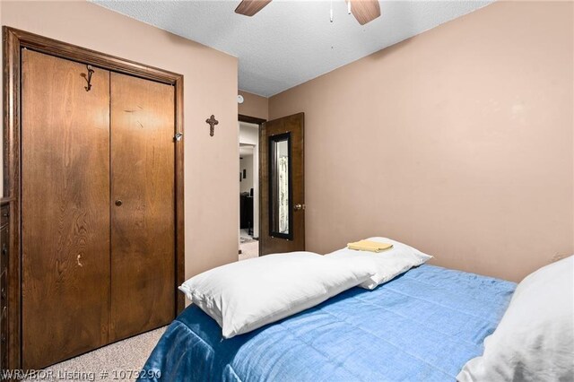 carpeted bedroom with ceiling fan and a closet