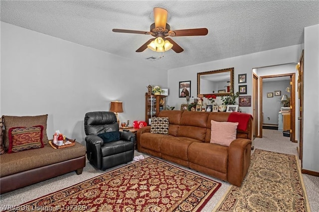 living room featuring ceiling fan and a textured ceiling