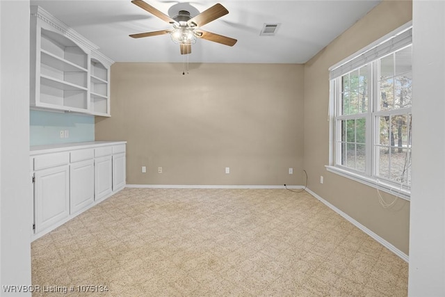 spare room featuring light carpet and ceiling fan