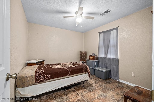112179 S 4776th Rd, Muldrow, OK 74948 - bedroom with a textured ceiling, baseboards, a textured wall, a ceiling fan, and stone finish floors