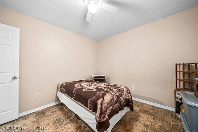 112179 S 4776th Rd, Muldrow, OK 74948 - bedroom featuring baseboards, ceiling fan, a textured ceiling, and stone finish flooring