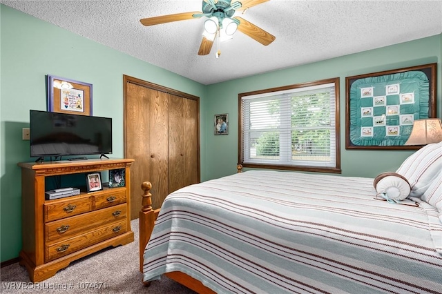 carpeted bedroom featuring ceiling fan, a closet, and a textured ceiling