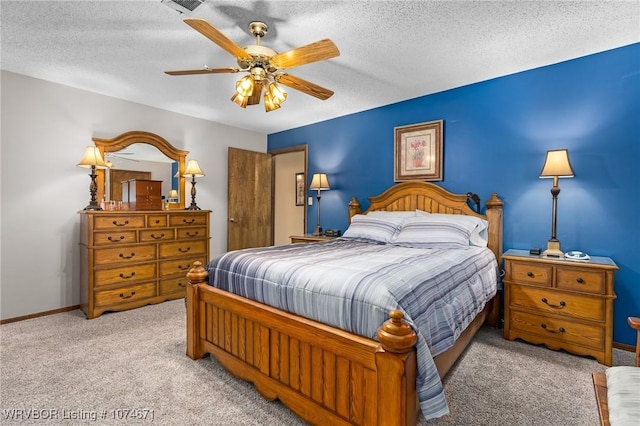 carpeted bedroom featuring a textured ceiling and ceiling fan