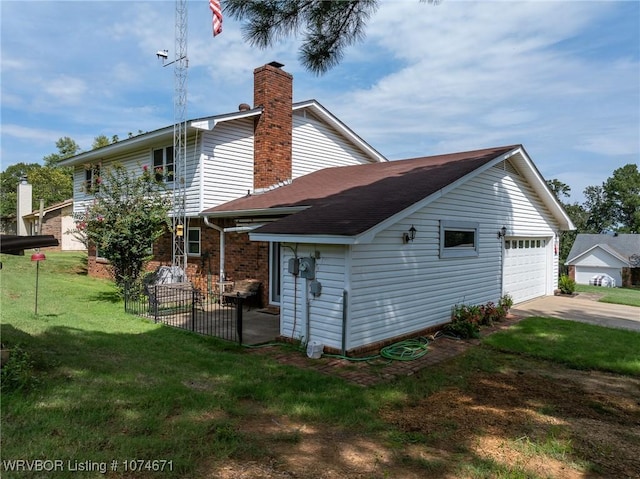 rear view of house with a garage and a lawn