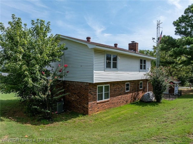 rear view of house featuring central AC unit and a yard