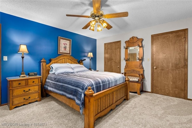 carpeted bedroom with ceiling fan and a textured ceiling