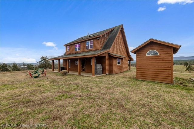 rear view of property featuring a yard and a shed