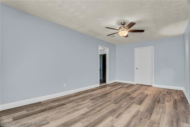 unfurnished room with light wood-type flooring, ceiling fan, baseboards, and a textured ceiling