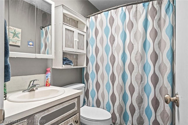 bathroom with toilet, a shower with shower curtain, and vanity