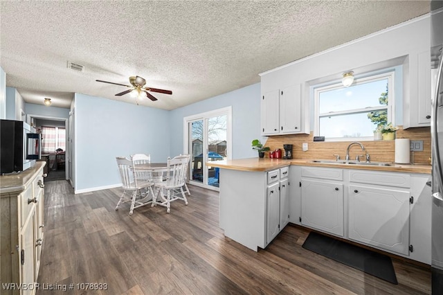 kitchen with light countertops, visible vents, and white cabinets