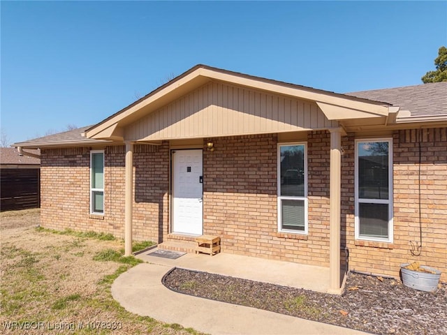 doorway to property with brick siding