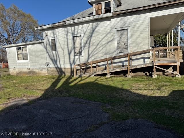 view of property exterior with a lawn and a deck