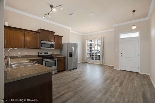 kitchen with sink, wood-type flooring, stainless steel appliances, and hanging light fixtures