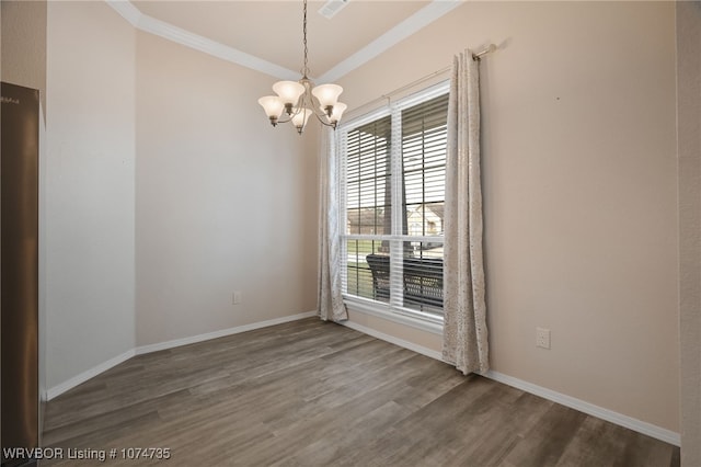 empty room featuring wood-type flooring, an inviting chandelier, and crown molding