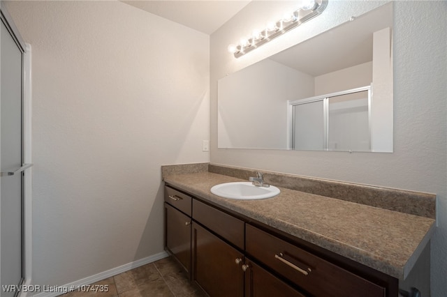 bathroom featuring tile patterned flooring, vanity, and a shower with door