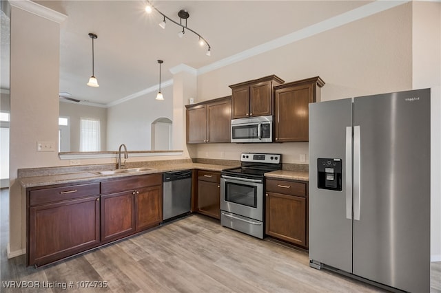 kitchen with sink, stainless steel appliances, crown molding, pendant lighting, and light wood-type flooring