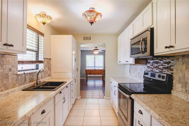 1515 M Cir, Barling, AR 72923 - kitchen featuring appliances with stainless steel finishes, a sink, decorative backsplash, a ceiling fan, and light tile patterned flooring
