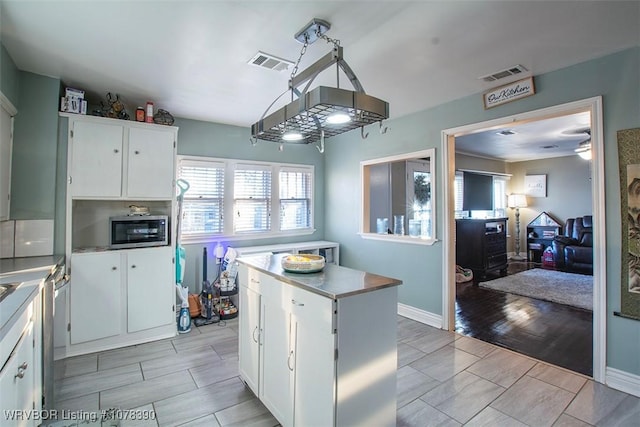 kitchen featuring appliances with stainless steel finishes, white cabinetry, and a kitchen island