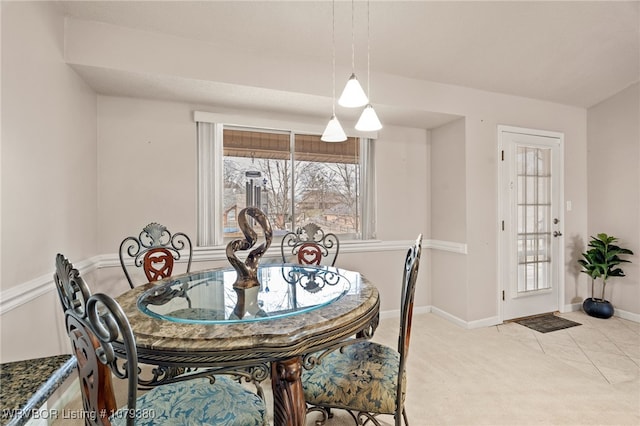 carpeted dining area featuring baseboards