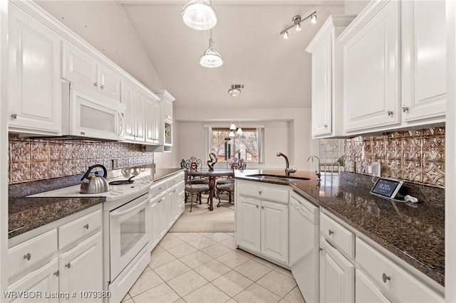 kitchen with lofted ceiling, white appliances, white cabinets, and a sink