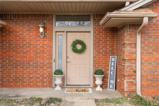 doorway to property with brick siding