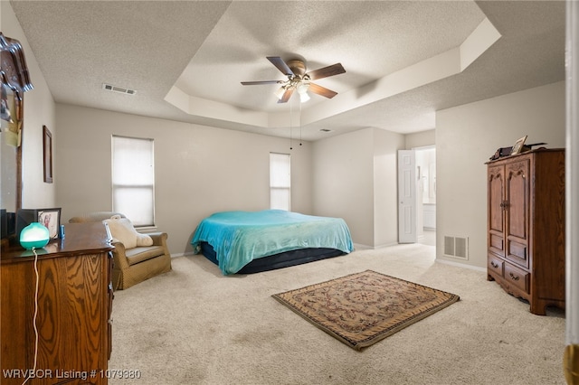 bedroom featuring carpet, a raised ceiling, and visible vents