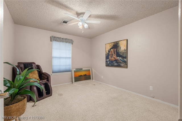 miscellaneous room with a textured ceiling, carpet floors, visible vents, baseboards, and a ceiling fan