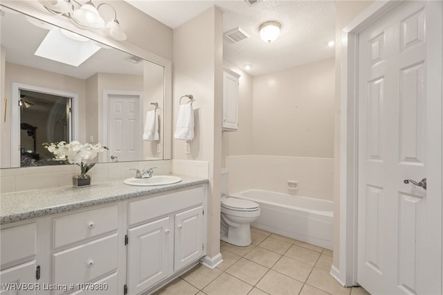 full bath featuring a garden tub, tile patterned flooring, a skylight, vanity, and visible vents