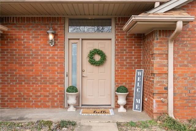 doorway to property featuring brick siding