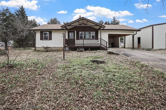 view of front of property with a shingled roof, an attached carport, and concrete driveway