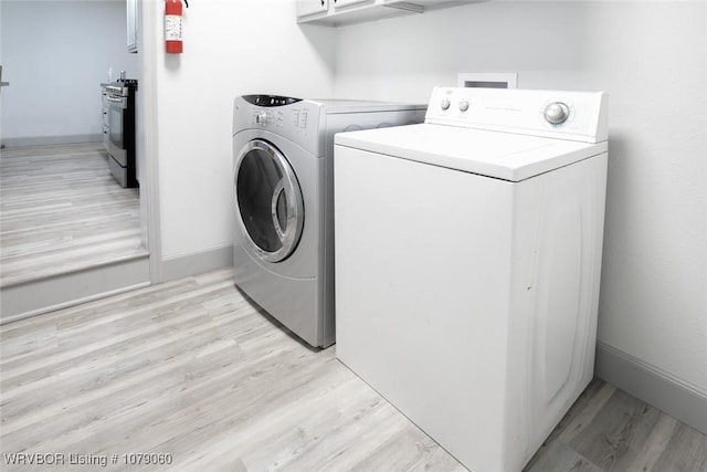 laundry room featuring laundry area, light wood finished floors, and washing machine and dryer