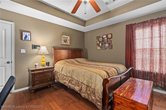 bedroom featuring dark wood finished floors, visible vents, a ceiling fan, and baseboards