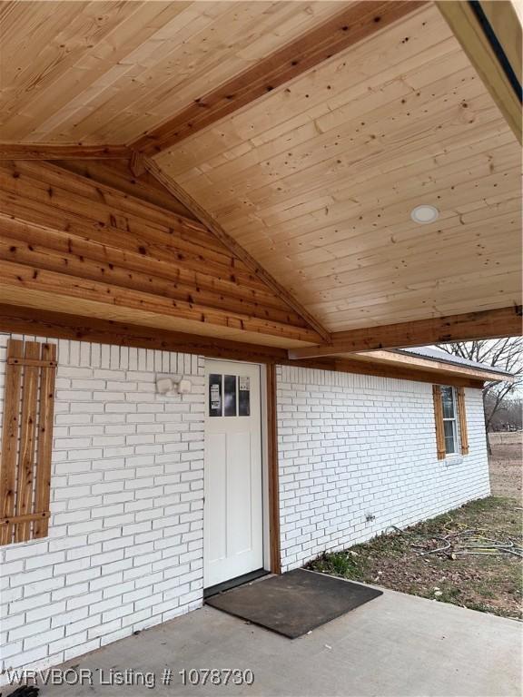 view of exterior entry featuring brick siding