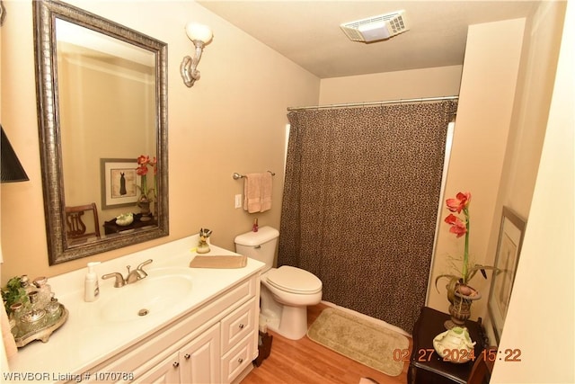 bathroom with a shower with curtain, toilet, vanity, and hardwood / wood-style flooring