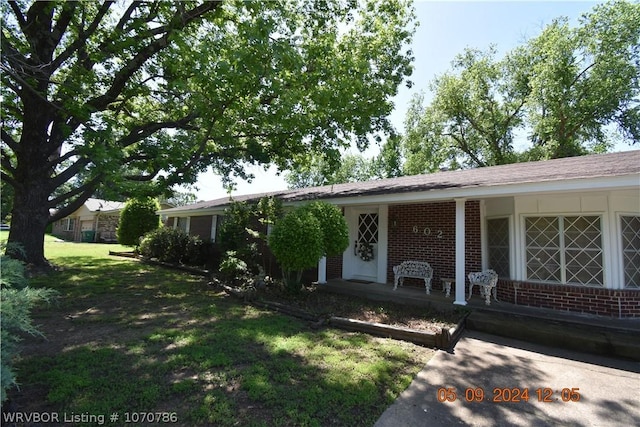 view of front of property featuring covered porch and a front yard