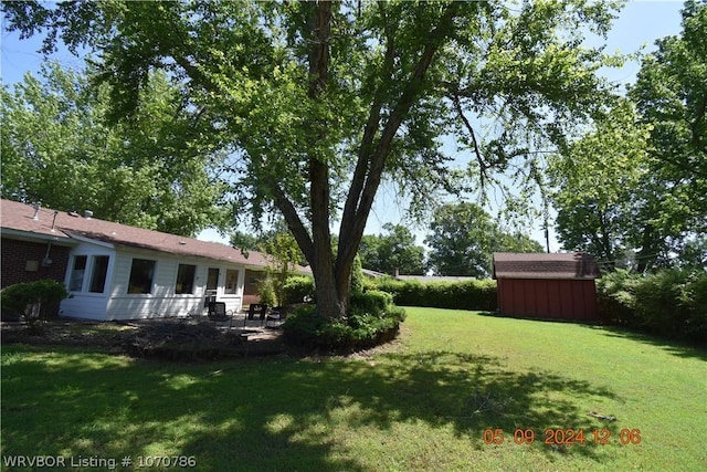 view of yard featuring a patio area and a storage shed