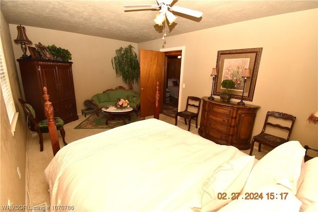 bedroom featuring carpet, ceiling fan, and a textured ceiling