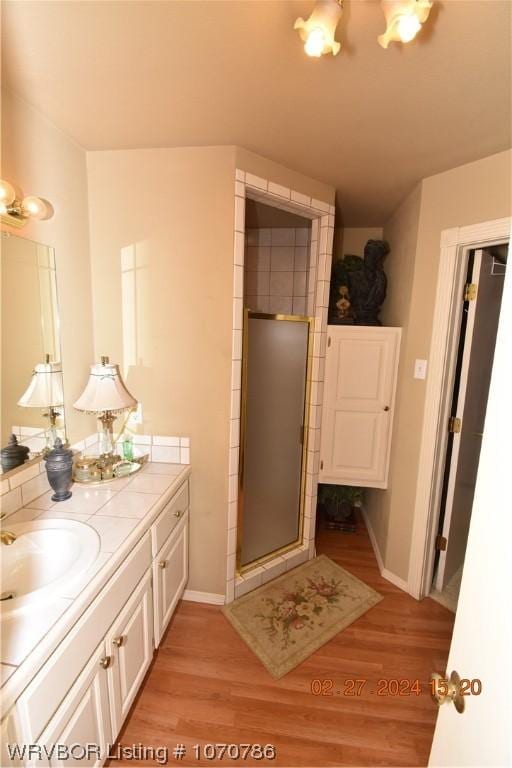 bathroom featuring vanity, wood-type flooring, and walk in shower