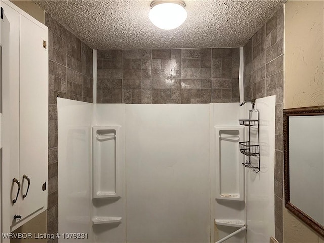 full bathroom with a walk in shower, a textured ceiling, and tile walls