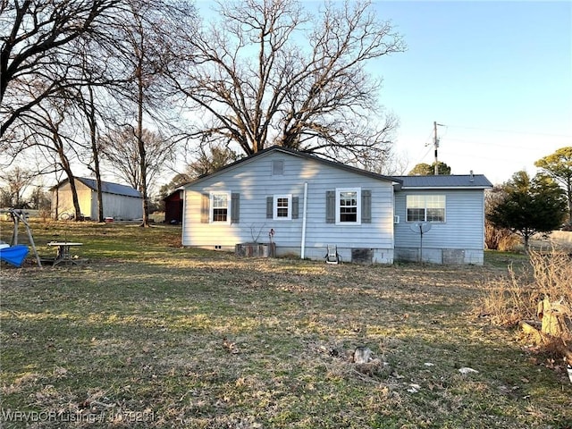 back of house with a chimney and a yard