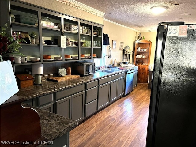 kitchen with ornamental molding, freestanding refrigerator, a sink, wood finished floors, and dishwasher