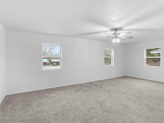 spare room with ceiling fan and carpet