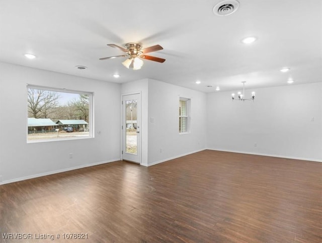 unfurnished living room with dark wood-type flooring and ceiling fan with notable chandelier