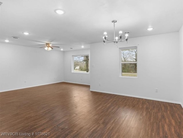 unfurnished room with dark wood-type flooring, plenty of natural light, and ceiling fan with notable chandelier