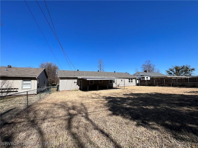 rear view of property featuring a fenced backyard