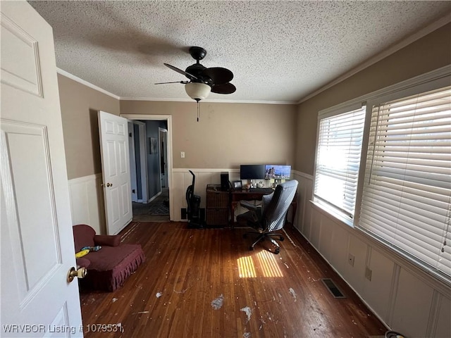 home office with hardwood / wood-style flooring, crown molding, a wainscoted wall, and visible vents