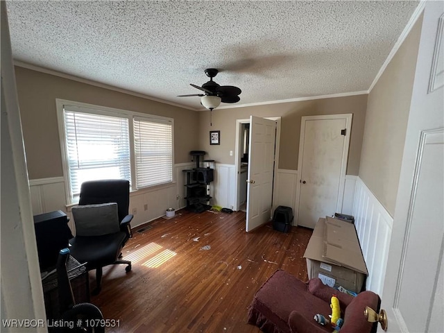 office area with wood finished floors, a wainscoted wall, ceiling fan, a textured ceiling, and crown molding