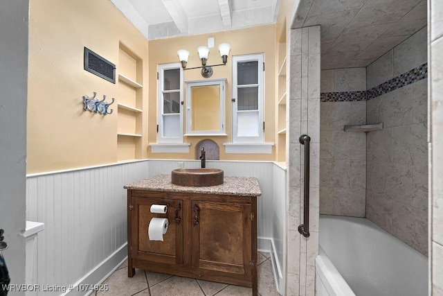 bathroom featuring built in shelves, vanity, tile patterned floors, and tiled shower / bath