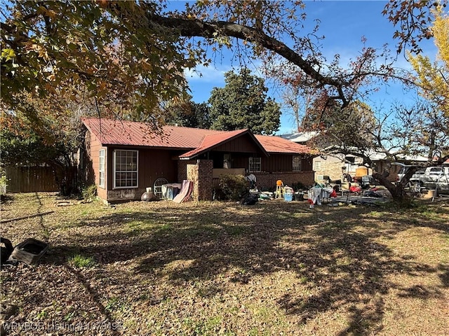 view of front of property featuring metal roof and fence